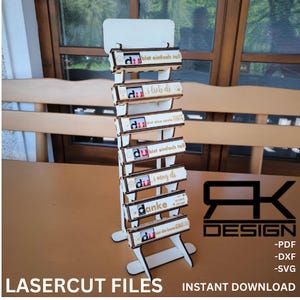 Puede incluir: Un soporte de madera con seis ranuras para sostener pequeñas cajas de madera. Cada caja tiene un mensaje diferente en alemán, incluyendo "du bist einfach toll" y "ich lieb di".