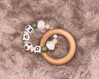 Wooden baby rattle personalized with the first name and colors of your choice, with safety clasp, entirely in silicone except the ring.