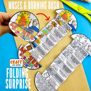 Pode incluir: Um projeto de artesanato com o texto "Moses & Burning Bush" e "Folding Surprise". O design inclui ilustrações de Moisés e uma sarça ardente, com texto e imagens adicionais. O artesanato está em uma superfície de madeira com tesouras e cola visíveis.