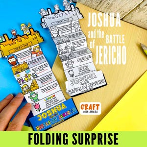May include: A colorful craft project featuring the story of Joshua and the Battle of Jericho. The folded paper design includes illustrations and text, with the words "Joshua and the Battle of Jericho" prominently displayed. The craft is on a wooden surface with a blue background.