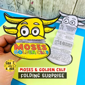 Könnte beinhalten: Ein gelbes und schwarzes Cartoon-Goldkalb mit dem Text "MOSES GOLDEN CALF" auf einem Oval. Das Kalb ist eine Klappüberraschung mit Illustrationen und Text. Die Worte "MOSES & GOLDEN CALF FOLDING SURPRISE" sind ebenfalls sichtbar.