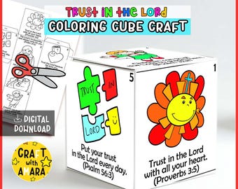 May include: A white cube craft with colorful illustrations and text. The cube features a flower with a cross, puzzle pieces with the words "Trust in the Lord", and Bible verses. The text reads "Trust in the Lord Coloring Cube Craft".