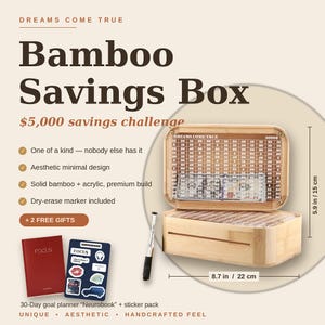 May include: A rectangular bamboo savings box with an acrylic front panel featuring a grid of numbers for a $5,000 savings challenge. It measures 8.7 inches by 5.9 inches and includes a dry-erase marker, a red Focus planner, and a sticker pack.