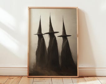 May include: A framed print of a dark, atmospheric illustration featuring three figures in black cloaks and pointed hats, resembling witches, standing in a row against a foggy background.