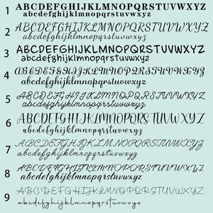 May include: A light blue background displays nine different font styles. Each style shows the uppercase and lowercase alphabet. The fonts vary from bold to cursive, offering a range of design options for text.