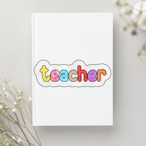May include: A white notebook with the word "teacher" written in colourful letters with a cloud-like border.