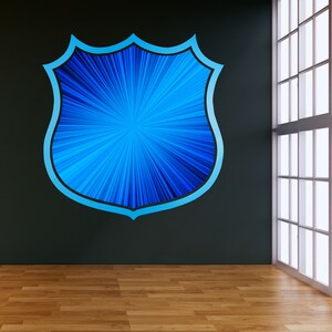 Puede incluir: Un gr&aacute;fico en forma de escudo azul y blanco con un patr&oacute;n radial en una pared negra.