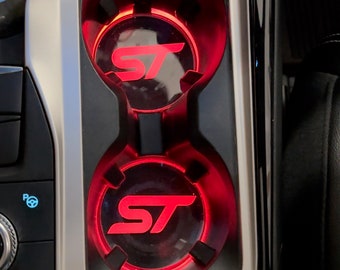 May include: Two red illuminated cup holders with the letters "ST" in white inside each holder.
