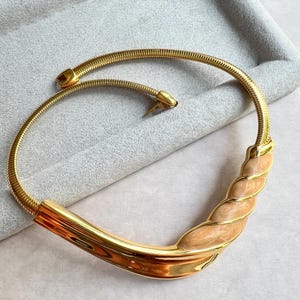 Gargantilla de cadena flexible NAPIER con diseño de libro vintage, engaste de metal dorado pulido y pieza central de esmalte color melocotón perlado, años 80, firmada.