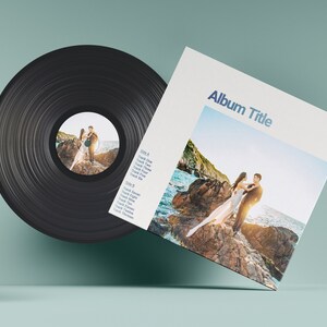 May include: A black vinyl record with a white label featuring a couple standing on rocks by the ocean. The album cover is white with the text "Album Title" in blue and a photo of the couple on the rocks. The album cover also includes a tracklist for Side A and Side B.