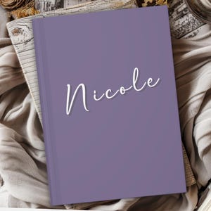 May include: A purple notebook with the name "Nicole" written in white cursive on the front cover.