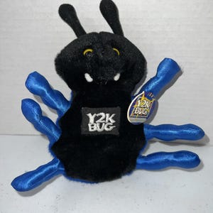 May include: A black plush bug toy with six shiny blue legs, two antennae, and yellow eyes. The center of the body features a black patch with the white text Y2K BUG. A circular tag attached to the side also displays the text Y2K BUG in yellow.