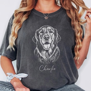 May include: Dark grey t-shirt with a black and white illustration of a Golden Retriever's face. The dog's name, "Charlie," is written in cursive below the image. The shirt has a vintage, washed appearance.
