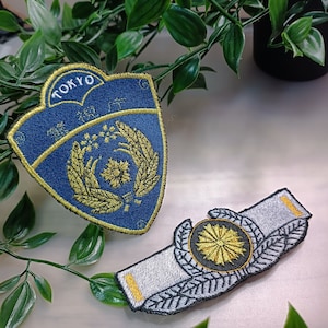 May include: Two embroidered patches, one blue with gold trim and the word "TOKYO" and the other white with gold trim and a gold and black emblem.