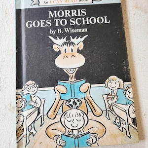以下が含まれることがあります： B. Wiseman著の「Morris Goes to School」というタイトルのヴィンテージ子供向けの本。表紙には、本を読む漫画のヘラジカと、他の漫画の子供たちが描かれています。この本は「An I Can Read Book」シリーズの一部です。