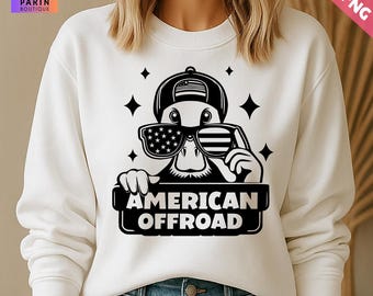 May include: Cream-coloured sweatshirt with a graphic of a duck wearing sunglasses with an American flag design and a baseball cap. The text "AMERICAN OFFROAD" is displayed below the duck. The design includes stars and is suitable for casual wear.