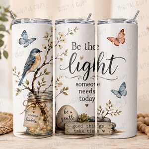 May include: White stainless steel tumbler with a floral and butterfly design. The tumbler features the text "Be the light someone needs today" and "choose kindness". A bird is perched on a branch.