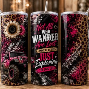 May include: A cylindrical stainless steel tumbler with a straw, featuring a pink jeep, sunflower, and leopard print design. The text reads: Not All WHO WANDER Are Lost SOME OF US ARE JUST EXPLORING THE GOOD LIFE. The background includes tire tracks.