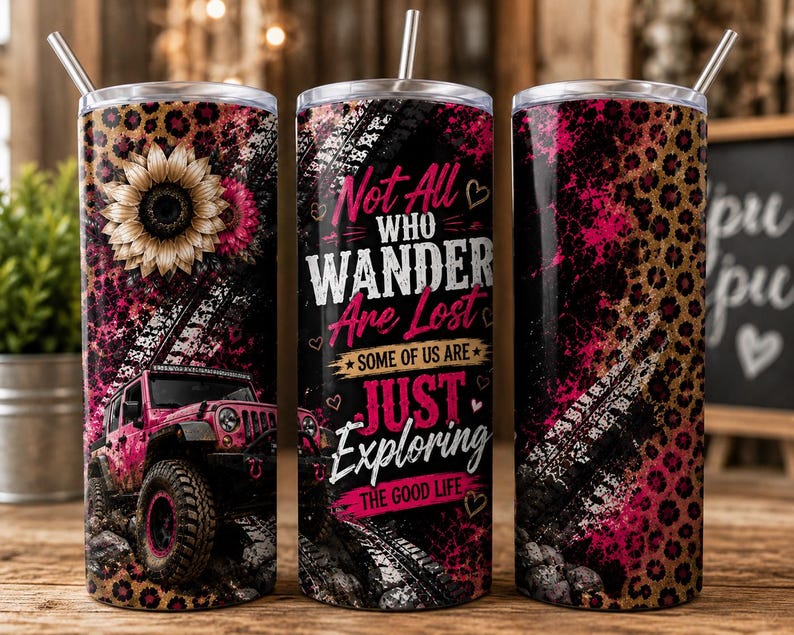 May include: A cylindrical stainless steel tumbler with a straw, featuring a pink jeep, sunflower, and leopard print design. The text reads: Not All WHO WANDER Are Lost SOME OF US ARE JUST EXPLORING THE GOOD LIFE. The background includes tire tracks.