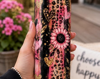 May include: A tall cylindrical tumbler with a clear lid and a metal straw. The exterior features a vertical design with black stripes, pink brushstrokes, leopard print patterns, gold glitter hearts, and a large pink sunflower graphic.