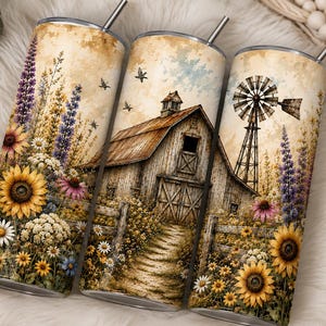May include: Three cylindrical metal tumblers with metal straws, featuring a wrap-around print of a rustic barn, a windmill, and a field of sunflowers, lupines, and daisies in a vintage, sepia-toned color palette with a clear sky and birds.