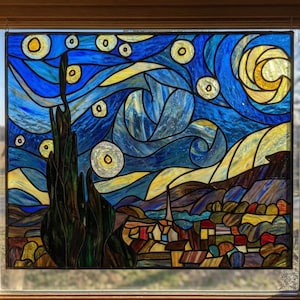 May include: Stained glass panel showing a night scene with a swirling blue sky, yellow stars, and a crescent moon. The artwork features a village with colourful rooftops and a dark, textured tree in the foreground. The panel is framed in wood.