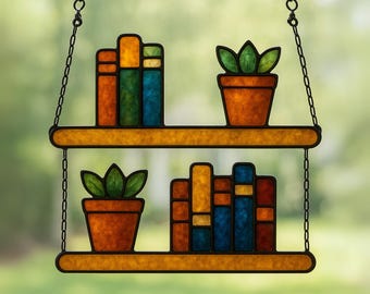 Puede incluir: Estantería colgante de vidrieras con dos niveles. Cada nivel contiene una maceta de terracota con una planta verde y una pila de libros coloridos. Los libros son naranjas, amarillos, azules y verdes. La estantería está suspendida por una cadena negra.