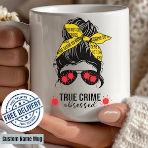 May include: White ceramic mug featuring a graphic of a woman with sunglasses and a yellow headband with "Crime Scene Do Not Cross" text. The mug reads "TRUE CRIME obsessed" with red splatter accents.