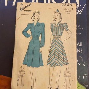 Puede incluir: Patrón de costura vintage para un vestido entallado. El patrón es de Advance Pattern, número 2649, talla 12, busto 76 cm, cadera 84 cm. El patrón presenta un vestido a rayas azules y blancas y un vestido azul sólido.