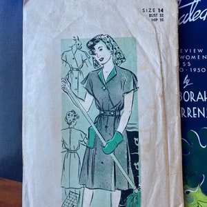 May include: Vintage sewing pattern featuring a woman in a dress with a green collar and belt, holding a mop. The pattern is size 14, with a bust of 32 inches and a hip of 35 inches. The pattern number is 1721.