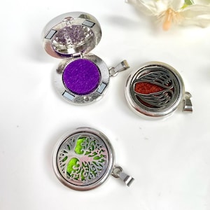 Può includere: Tre ciondoli in argento stile medaglione con diversi design. Il primo ciondolo ha un cuscinetto in feltro viola all'interno. Il secondo ciondolo ha un cuscinetto in feltro rosso con un design ad ala. Il terzo ciondolo ha un cuscinetto in feltro verde con un design ad albero della vita.