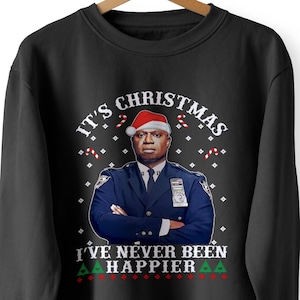 May include: Black sweatshirt with a Christmas-themed design featuring a man wearing a Santa hat and the text "It's Christmas I've never been happier."