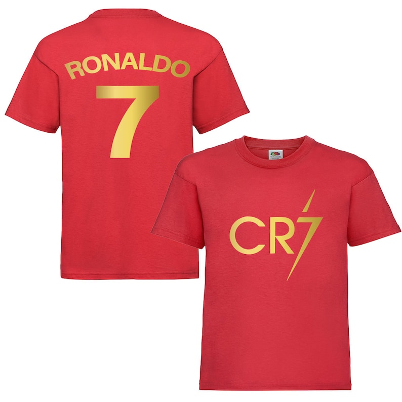 Pode incluir: Camiseta vermelha com letras douradas nas costas que diz "RONALDO 7" e um design de raio dourado na frente que diz "CR7".