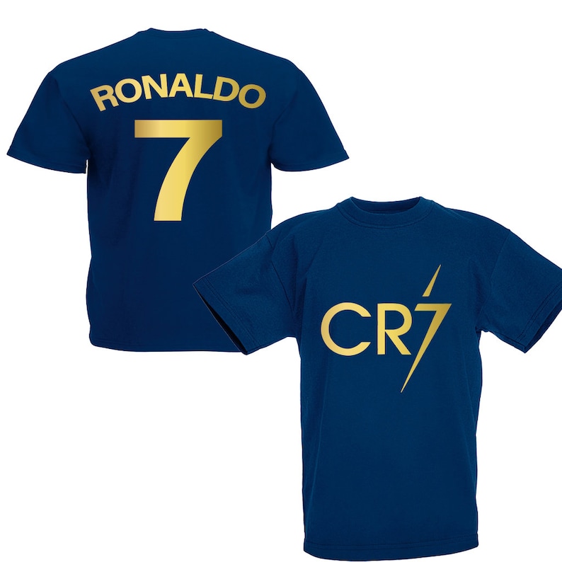 Pode incluir: Duas camisas azul marinho com letras douradas. A parte de tr&aacute;s de uma camisa tem o nome "RONALDO" e o n&uacute;mero "7". A parte da frente da outra camisa tem o logotipo "CR7" com um raio.
