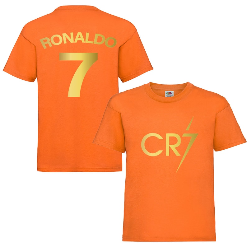 Pode incluir: Camiseta laranja com letras douradas. A parte de tr&aacute;s da camiseta diz "RONALDO 7". A parte da frente da camiseta diz "CR7" com um raio.