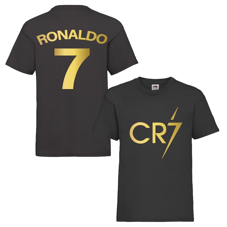 Pode incluir: Duas camisas pretas com letras douradas. Uma camisa tem "RONALDO 7" nas costas. A outra camisa tem "CR7" com um raio.