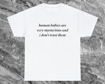Puede incluir: Camiseta blanca con el texto "human babies are very mysterious and i don't trust them" impreso en negro.