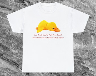 May include: White t-shirt with a yellow rubber duck lying down. The text "You think you've felt true fear? You think you've known actual pain?" is printed on the shirt.