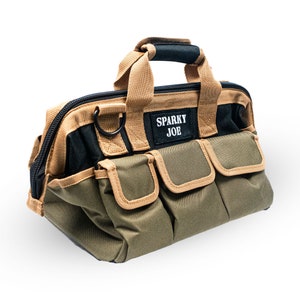 May include: A green and tan canvas tool bag with a black zipper and a brown handle. The bag has multiple pockets and a patch that says "Sparky Joe".