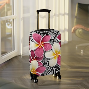 May include: A black suitcase with a floral print featuring pink and white flowers. The suitcase has a retractable handle and four wheels.