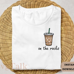 Op de afbeelding: Wit T-shirt met een afbeelding van een koffiedrank met ijs en de tekst "on the rocks".