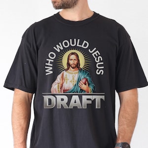 May include: Black t-shirt with a graphic of Jesus holding a football and the text "Who Would Jesus Draft".
