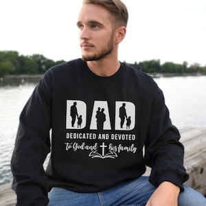 May include: Black sweatshirt with a white graphic design that says "DAD DEDICATED AND DEVOTED To God and his family" with a silhouette of a father and two children.
