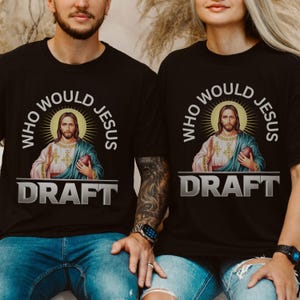 Puede incluir: Dos camisetas negras con un gr&aacute;fico de Jes&uacute;s sosteniendo un bal&oacute;n de f&uacute;tbol y el texto "Who Would Jesus Draft".