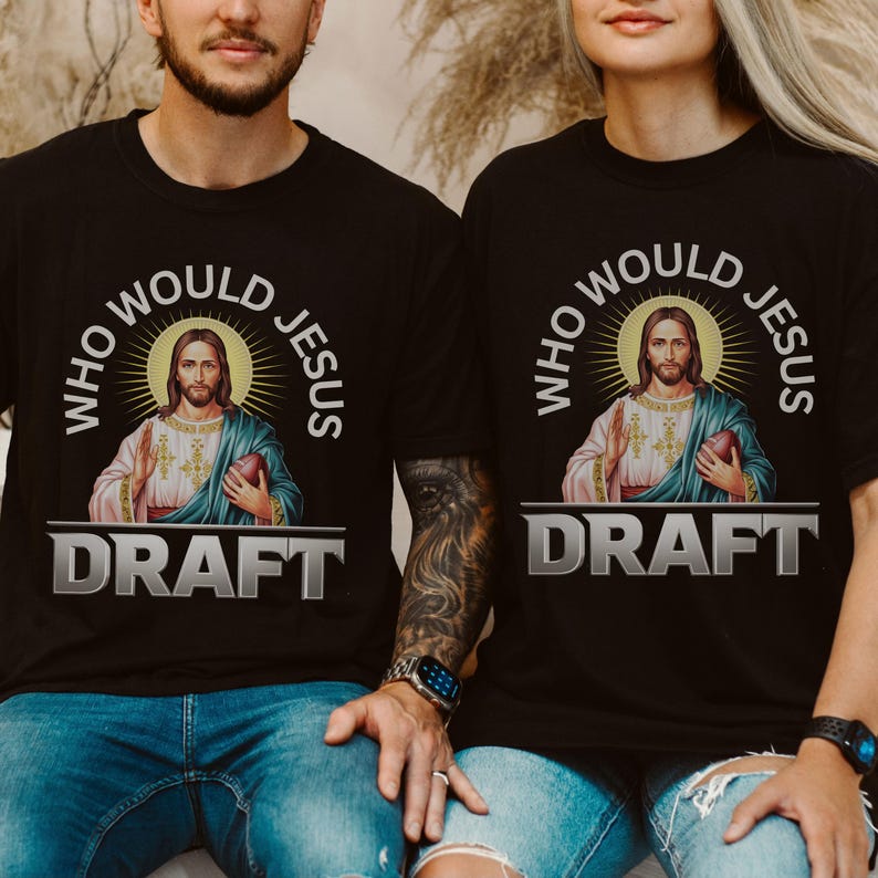 Puede incluir: Dos camisetas negras con un gr&aacute;fico de Jes&uacute;s sosteniendo un bal&oacute;n de f&uacute;tbol y el texto "Who Would Jesus Draft".