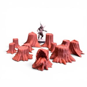 May include: A set of miniature red-brown tree stumps, arranged in a circle, with a small figurine of a horned creature in the middle. The stumps have detailed, textured surfaces, and the figurine is painted with various colours.