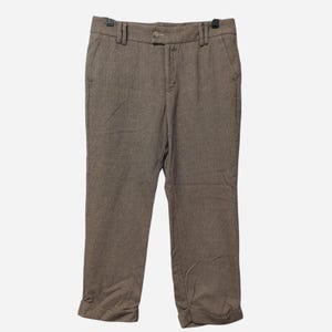 May include: Brown herringbone-patterned pants with a button closure and pockets. The pants have a straight leg and are cuffed at the bottom. The pants are hanging on a black hanger.