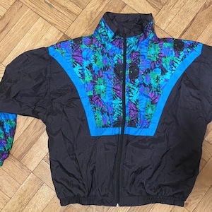 May include: A black windbreaker jacket with a blue and purple abstract print. The jacket has a zip fastening and a stand-up collar.