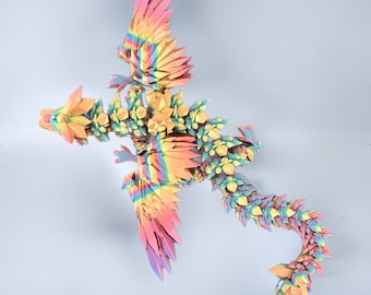 May include: A colorful origami dragon made of paper with a rainbow iridescent finish. The dragon is in a flying pose with its wings spread out and its tail curled up.