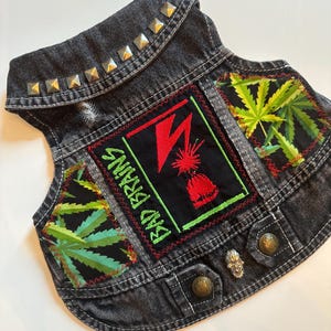 May include: Black denim vest with silver studs, green marijuana leaf patches, and a red and green "Bad Brains" patch.